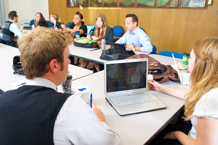 students with a laptop sitting in a business class